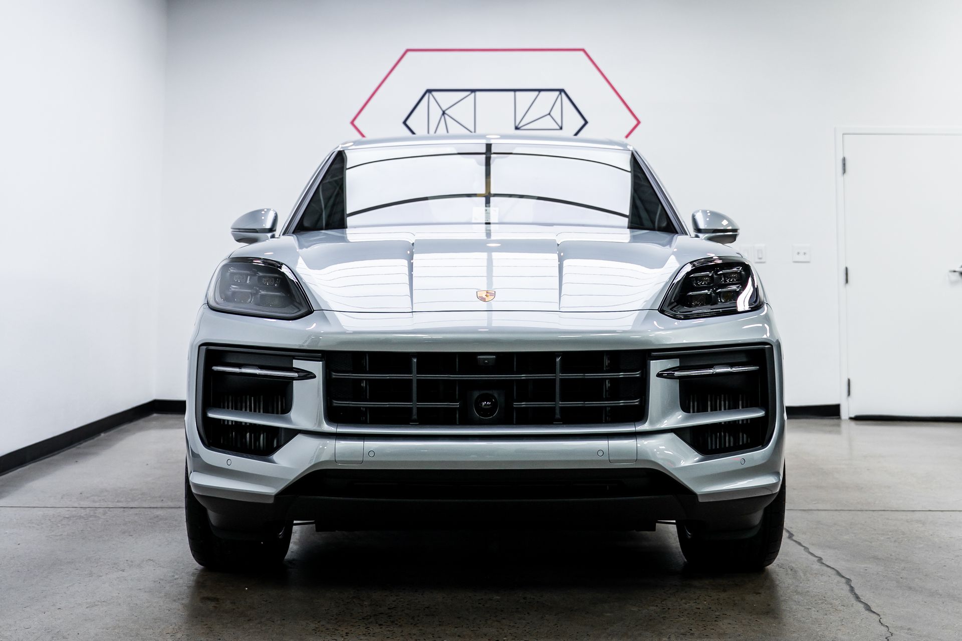 A silver porsche macan turbo is parked in a garage.