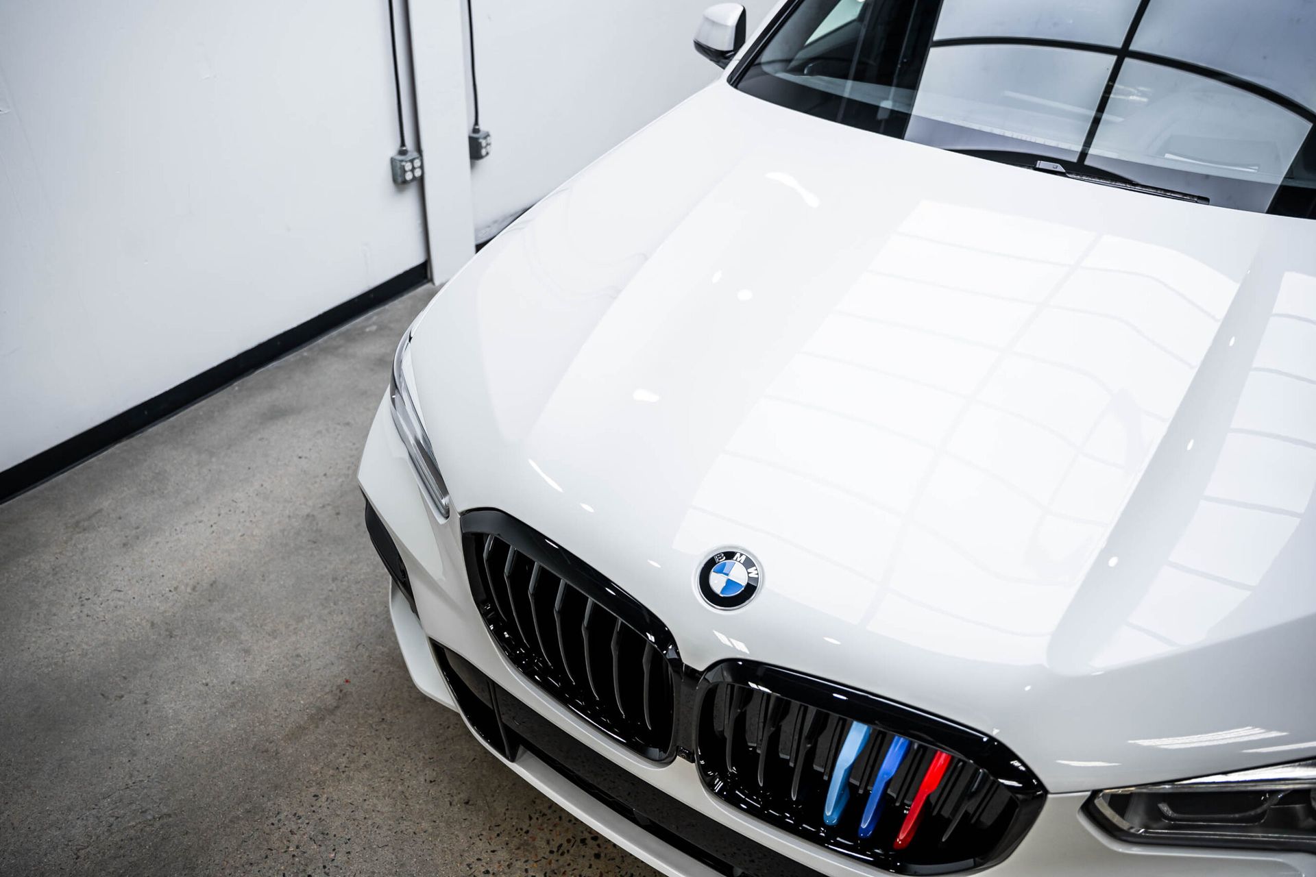 A white bmw is parked in a garage.