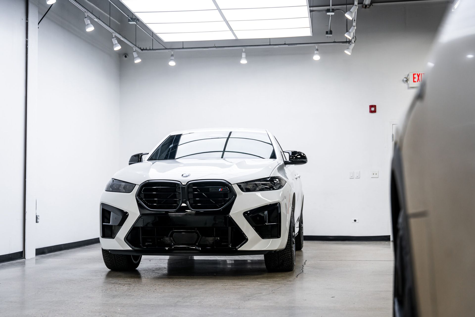 A white bmw x6 m is parked in a garage.