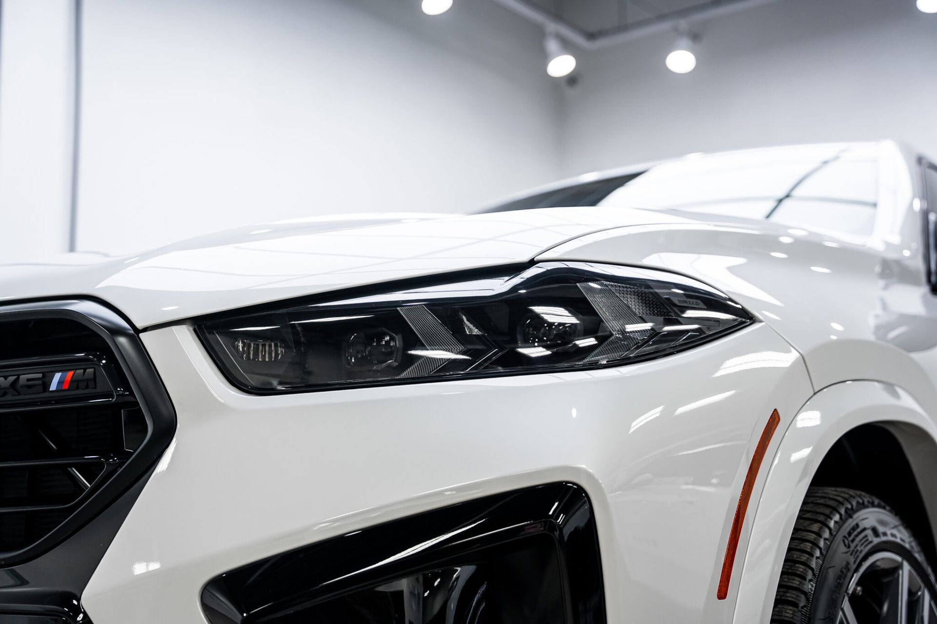 A white bmw x6 m is parked in a garage.