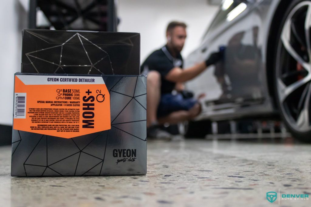 A man is kneeling down next to a box of dylon polish.