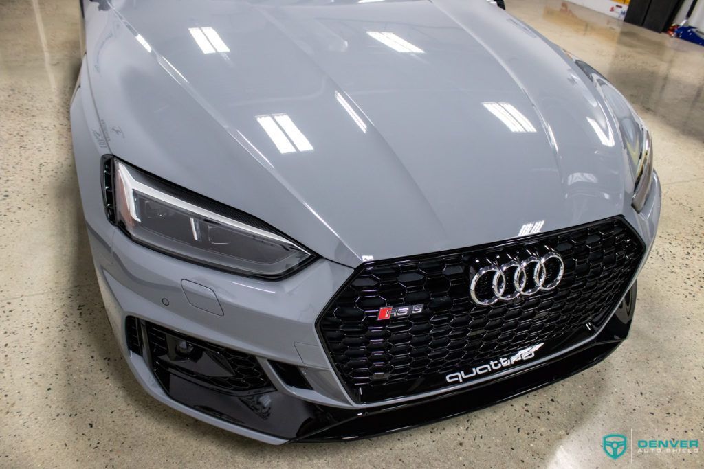 A gray audi rs5 is parked in a garage.