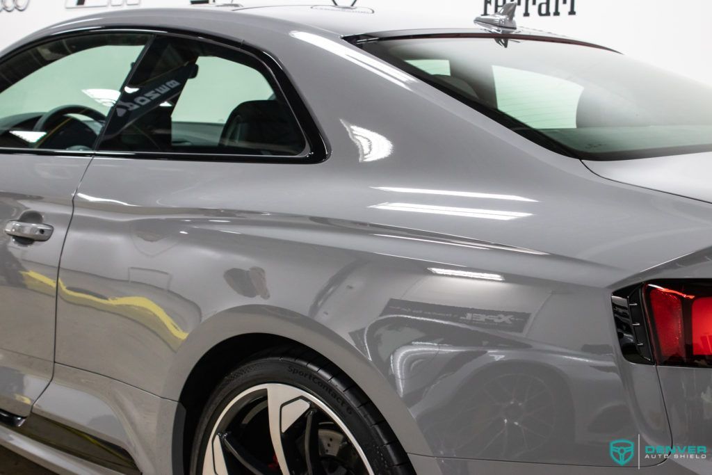 A gray audi a5 coupe is parked in a garage.