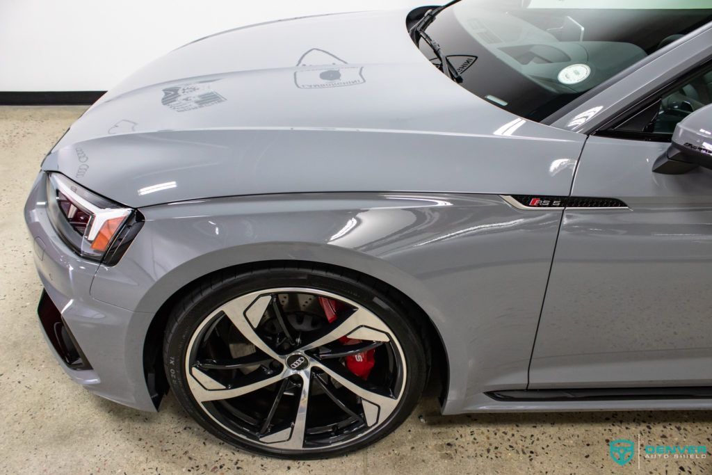 A gray audi rs 5 coupe is parked in a garage.