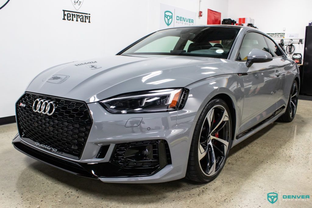 A grey audi a5 rs coupe is parked in a garage.