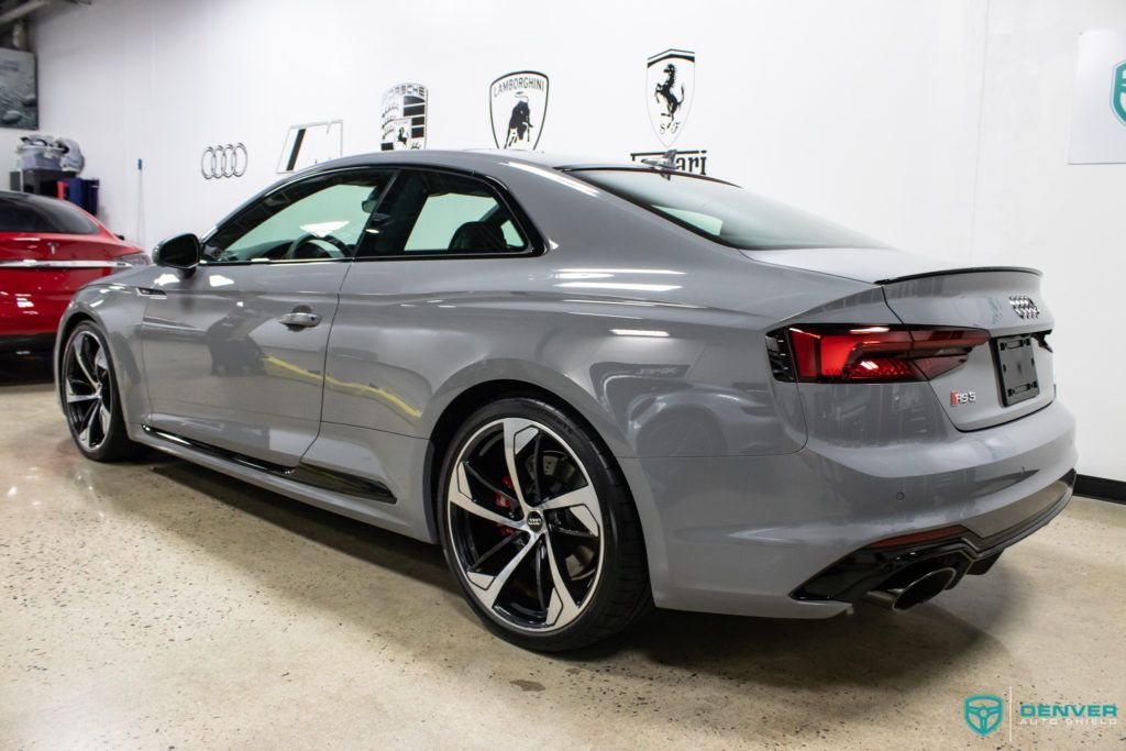 A gray audi rs 5 coupe is parked in a garage.