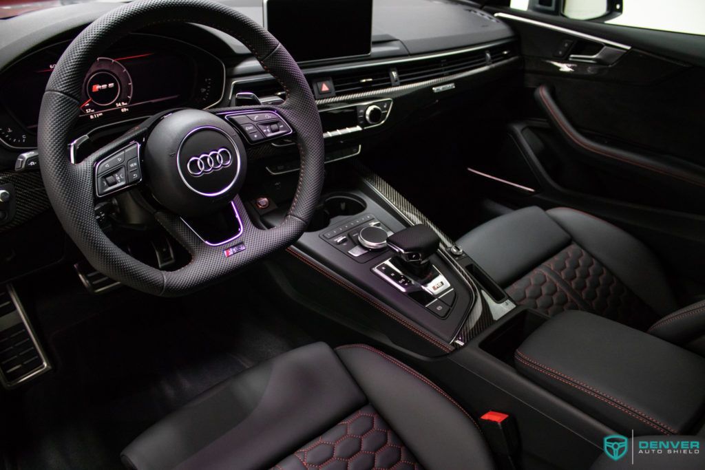 The interior of a car with a steering wheel and purple seats.