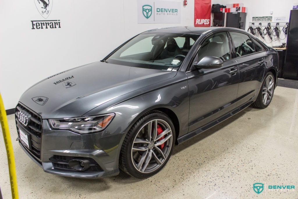 A gray audi a6 is parked in a garage.