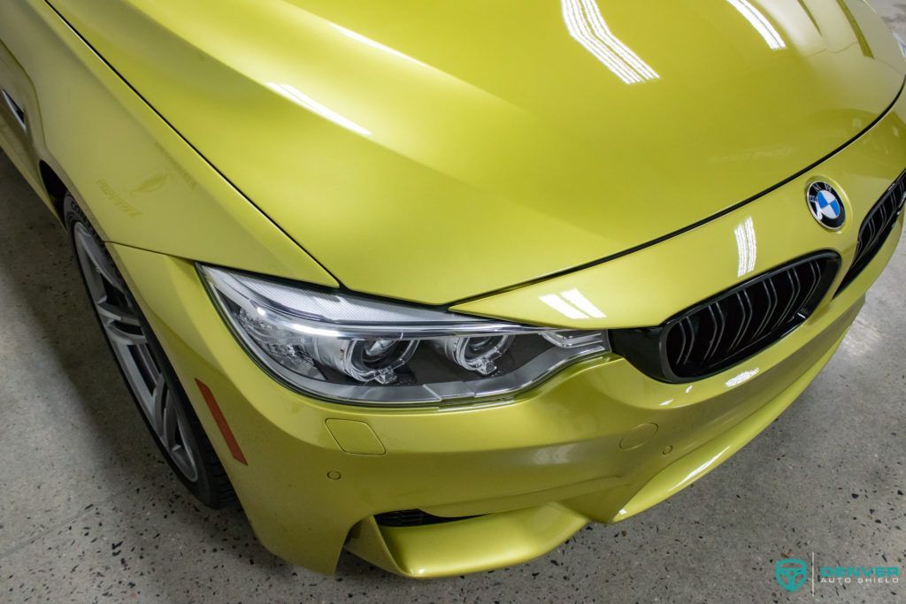 A yellow bmw m4 is parked in a garage