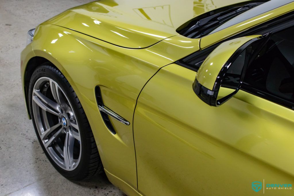 A yellow bmw is parked in a garage