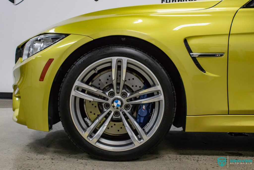 A yellow bmw m3 is parked in a garage