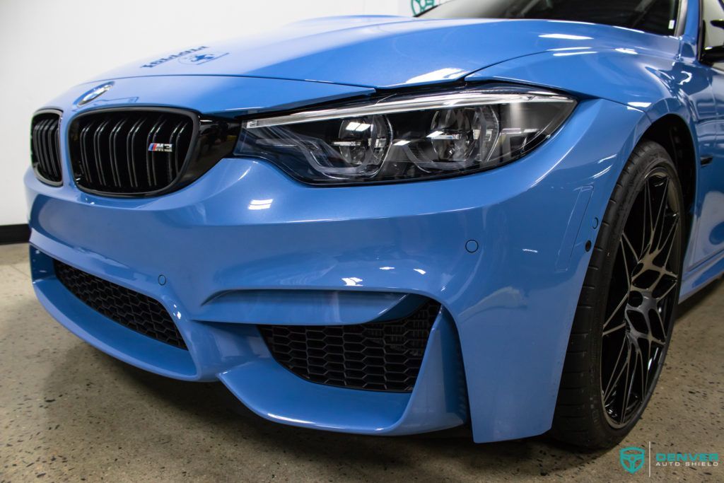 A blue bmw m3 is parked in a garage.