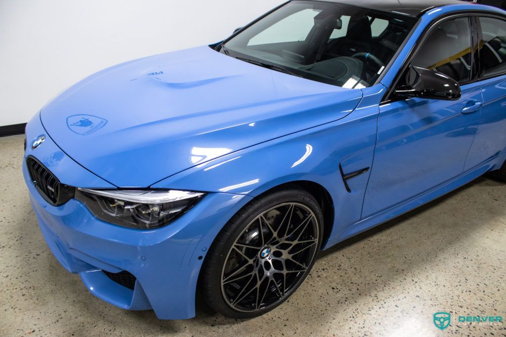 A blue bmw m3 is parked in a garage.