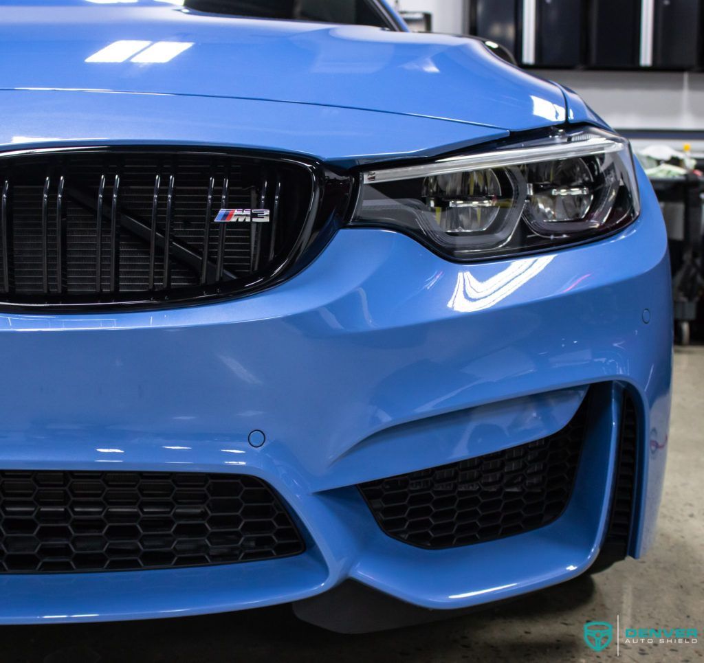 A close up of a blue bmw with a black grille