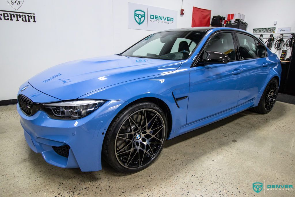 A blue bmw m3 is parked in a garage.