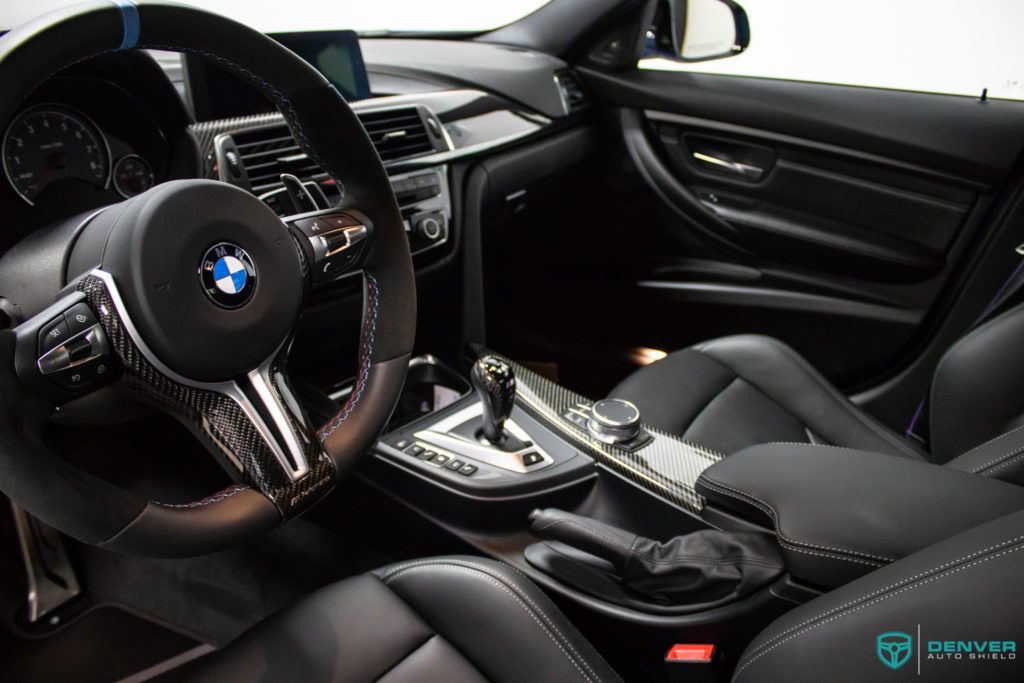 The interior of a bmw m3 with black leather seats and a steering wheel.