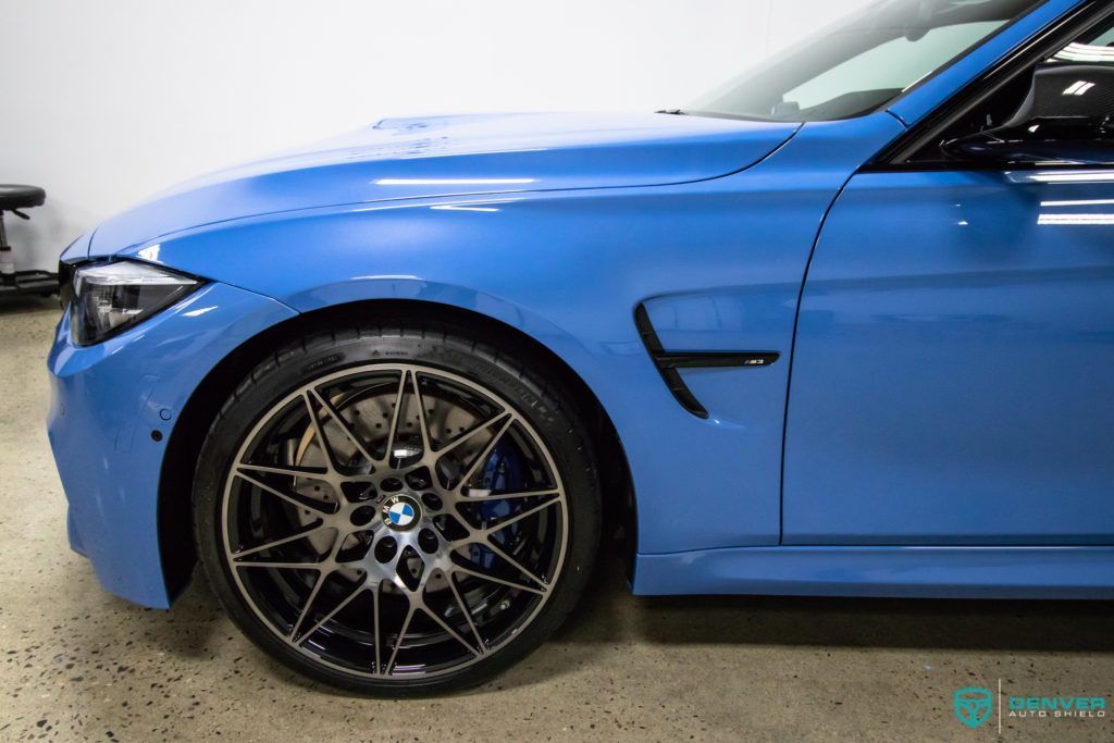 A blue bmw m3 is parked in a garage.