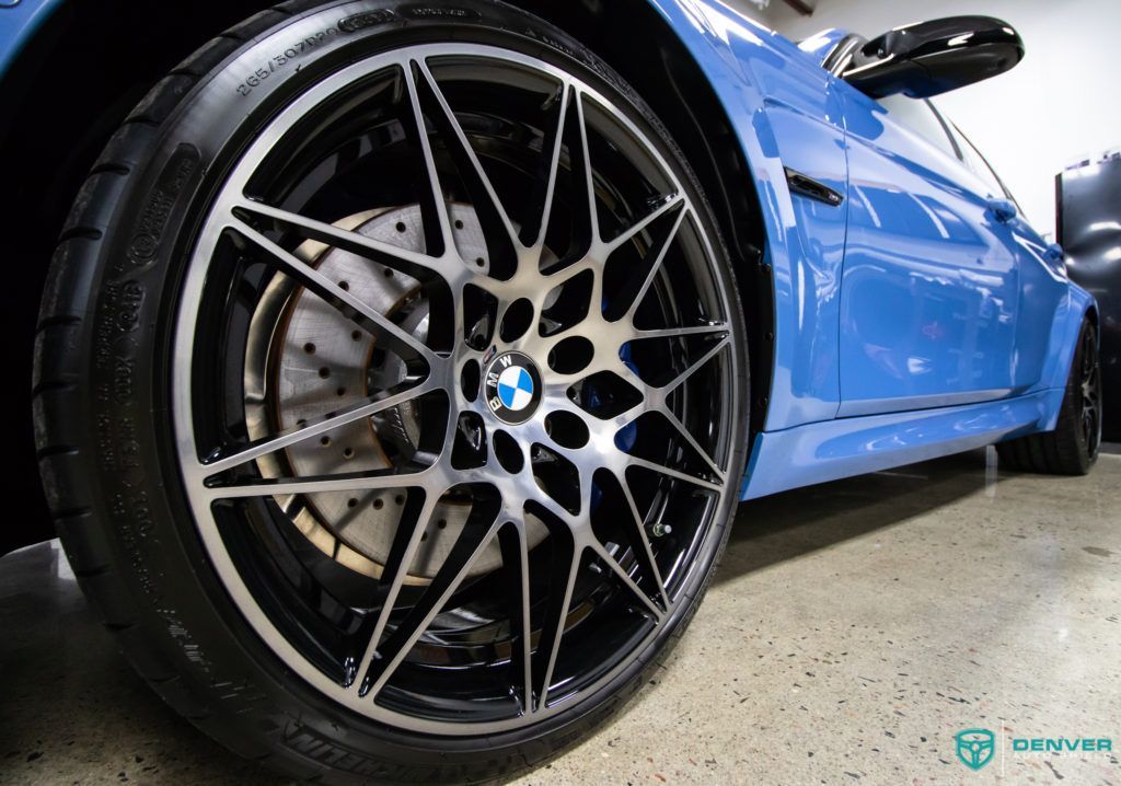 A close up of a blue bmw m3 with black wheels