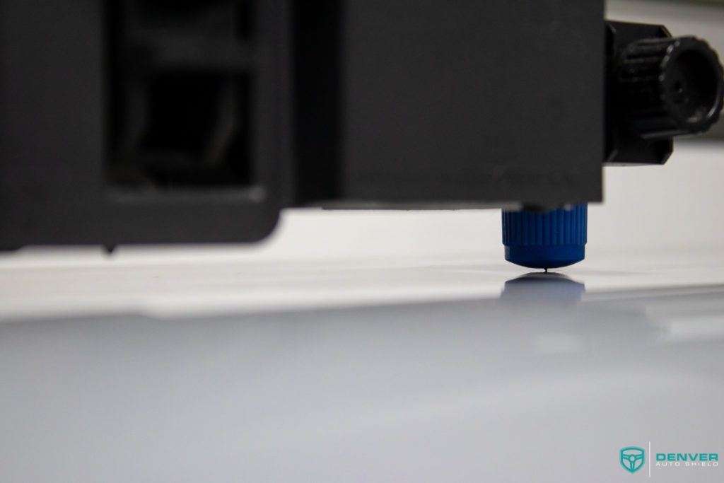 A close up of a machine cutting a piece of paper.