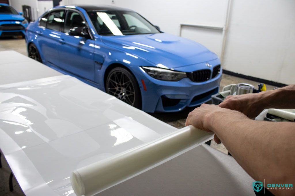 A blue bmw m3 is sitting on top of a white table.