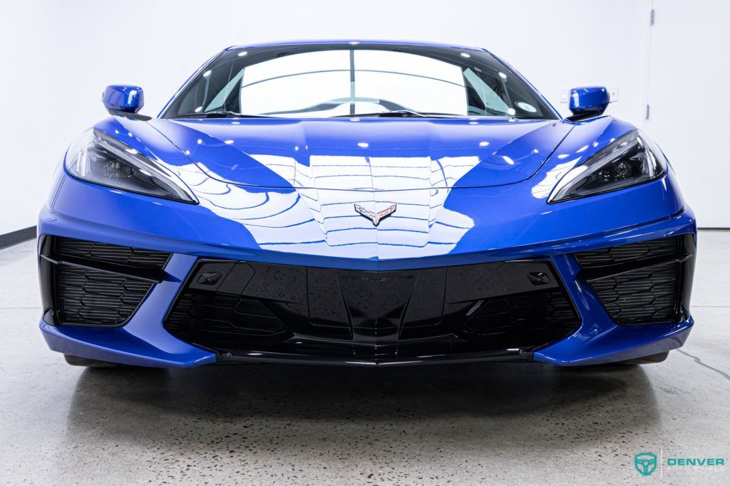 A blue sports car is parked in a garage.