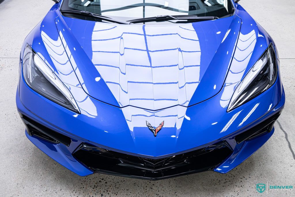 A blue sports car is parked in a garage