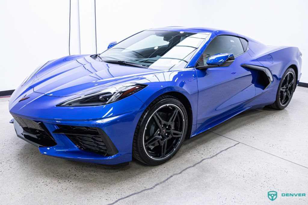 A blue sports car is parked in a garage.