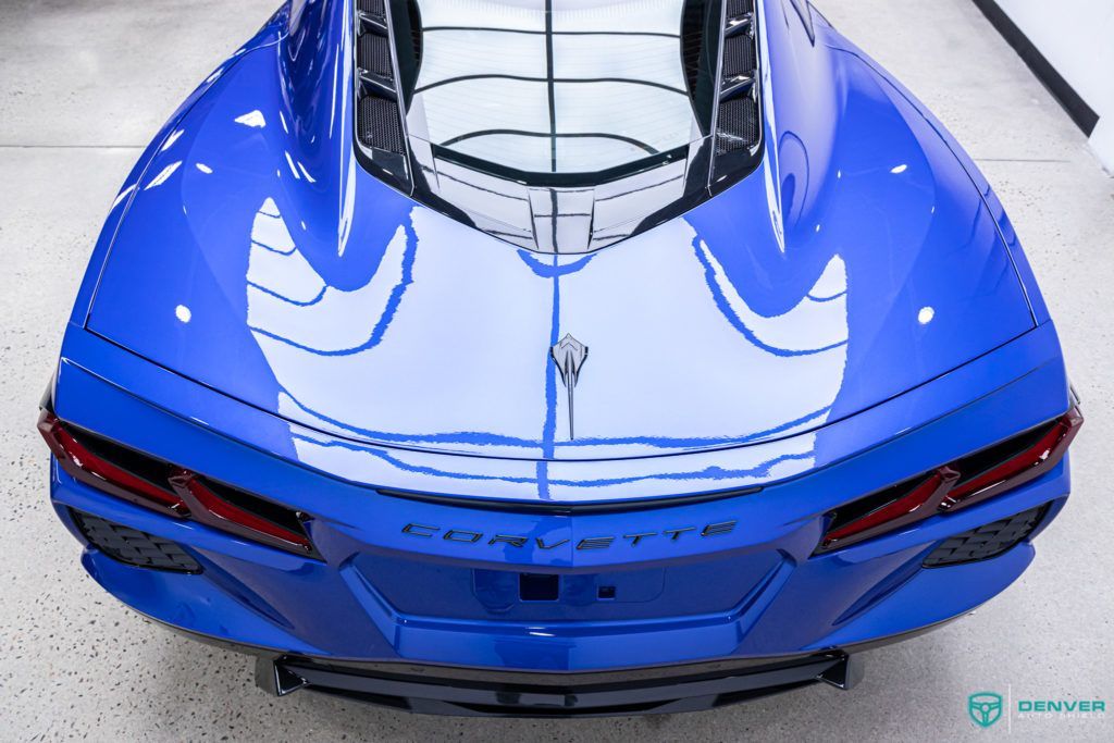 A blue corvette is parked in a garage