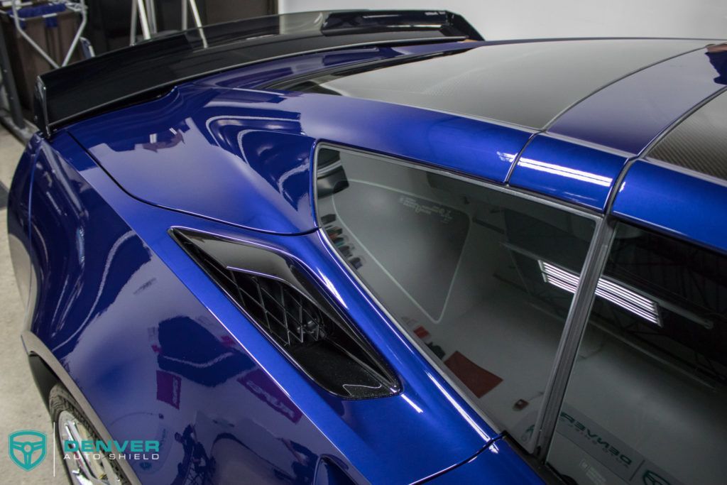 A close up of a blue car with a black roof