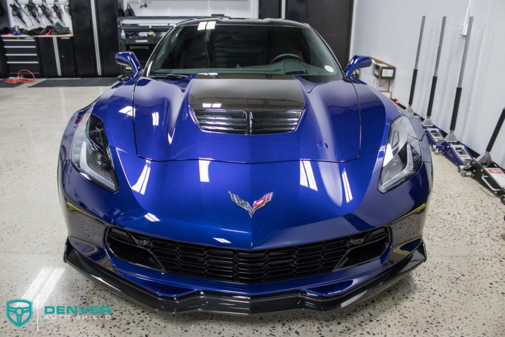 A blue sports car is parked in a garage.