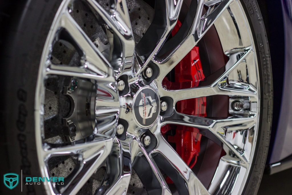 A close up of a car wheel with red brake calipers.