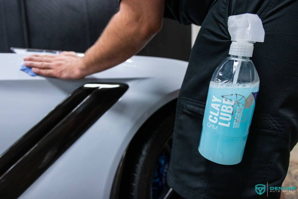 A person is cleaning a car with a spray bottle.