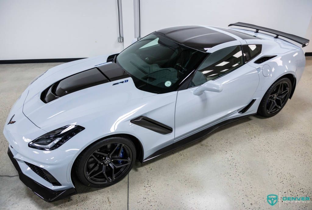 A white corvette zr1 is parked in a garage.