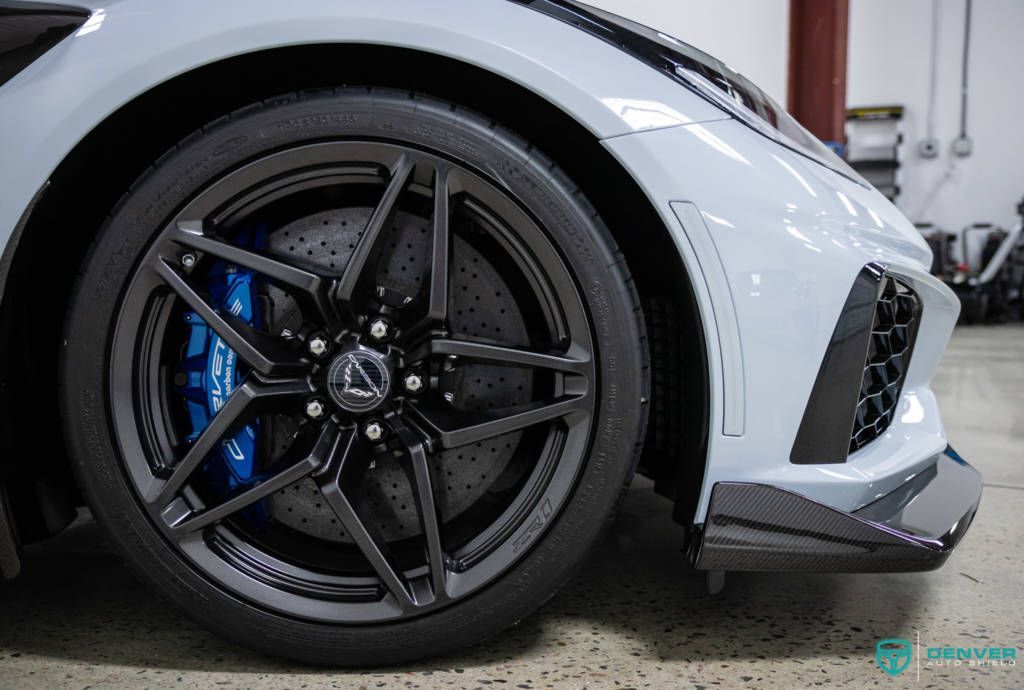 A close up of a car 's wheel and tire in a garage.