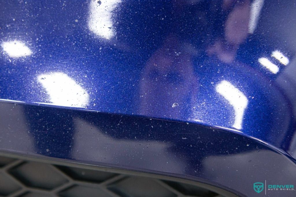 A close up of a blue car with a lot of sparkles on it.