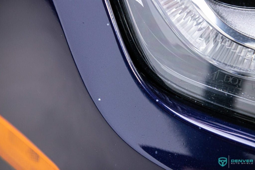 A close up of a blue car 's headlight.