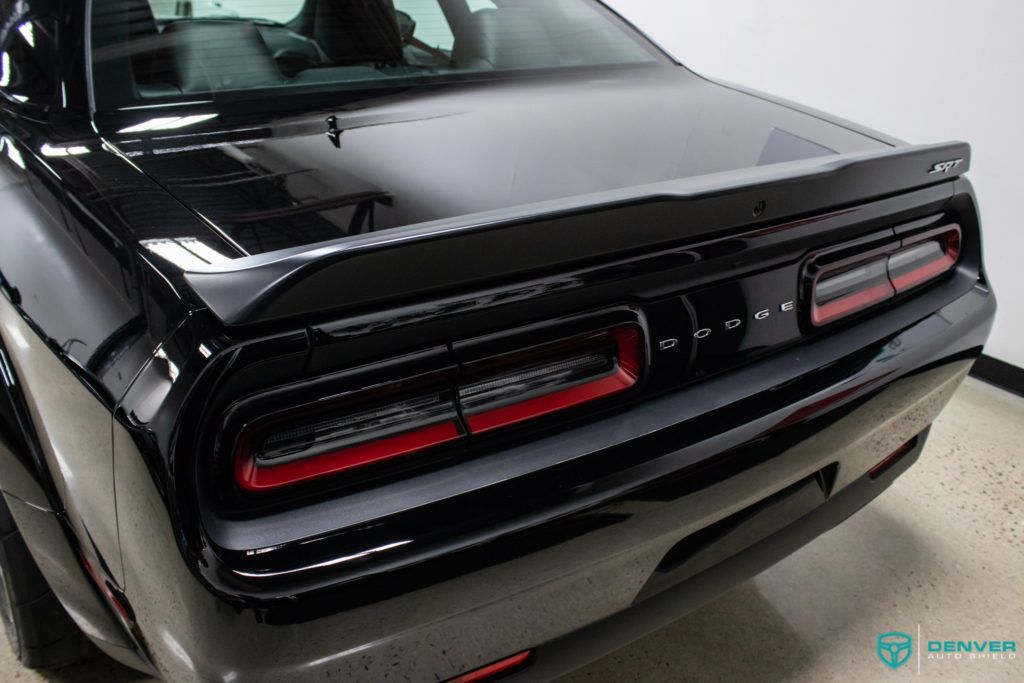 The rear end of a black dodge challenger is shown.