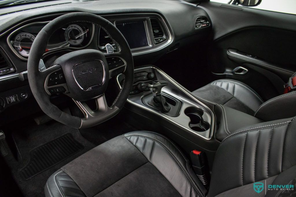 The interior of a dodge challenger with a steering wheel and seats.