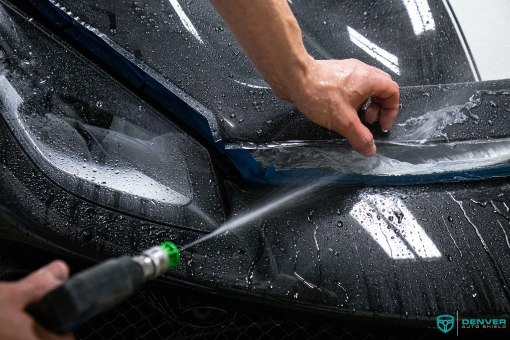 A person is cleaning a car with a spray bottle.