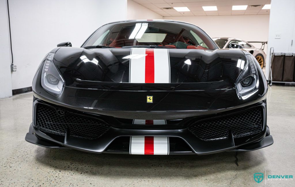 A black ferrari with a red and white stripe on the front