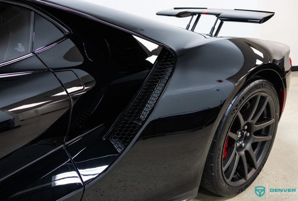 A black sports car is parked in a garage.