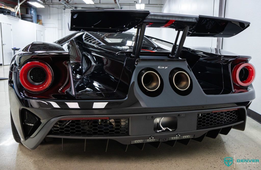 A black ford gt is parked in a garage.