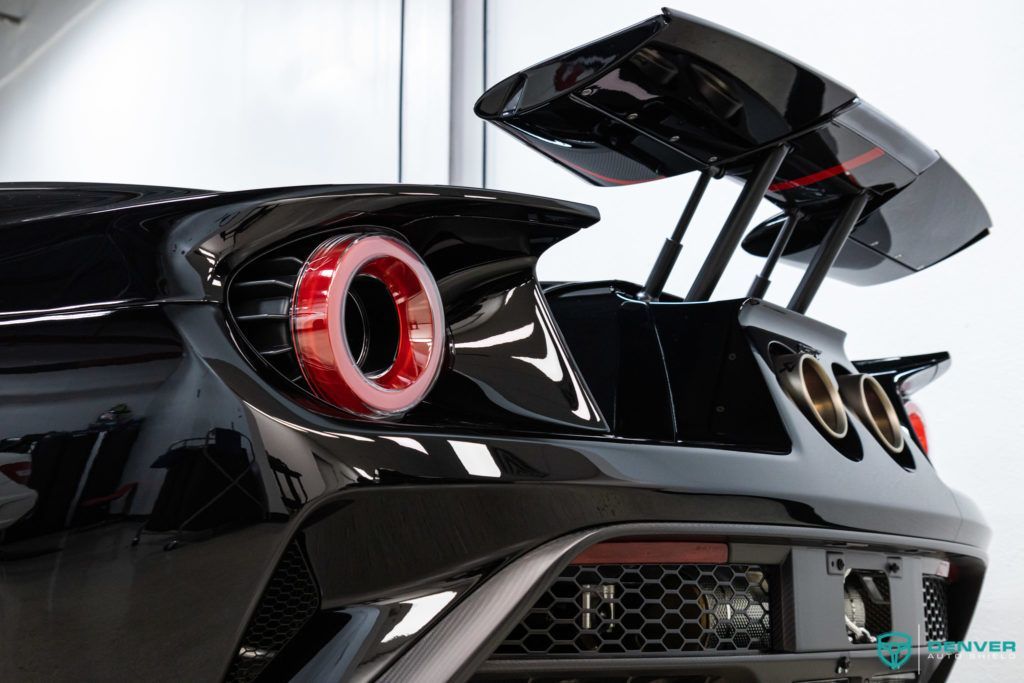 The rear end of a black sports car with a spoiler