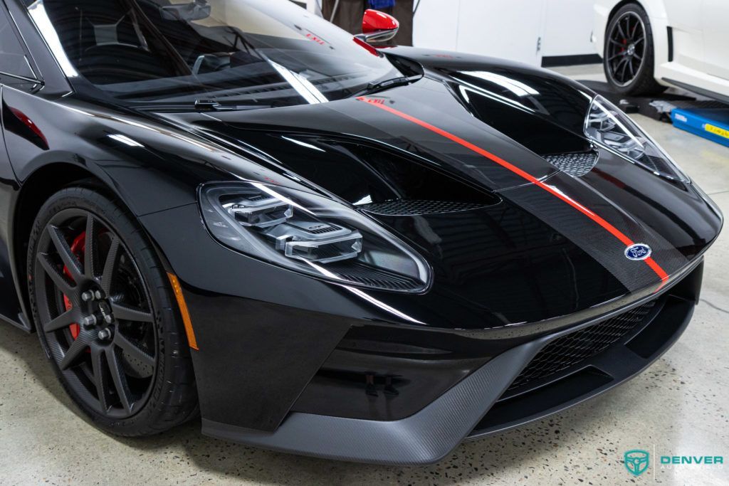 A black ford gt is parked in a garage.