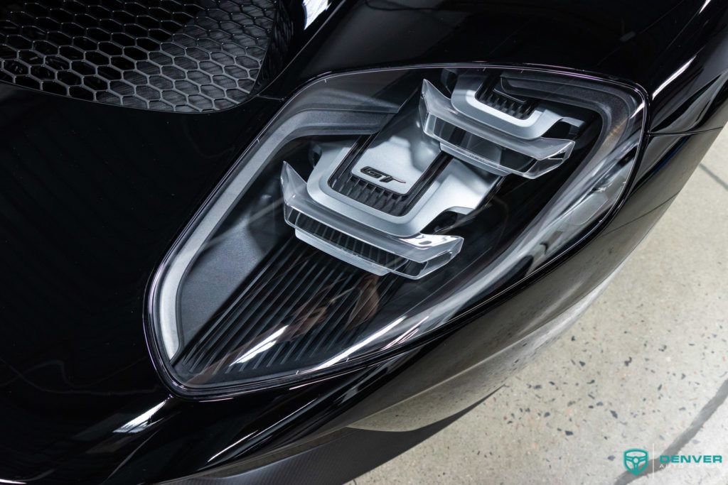 A close up of the headlight of a black car