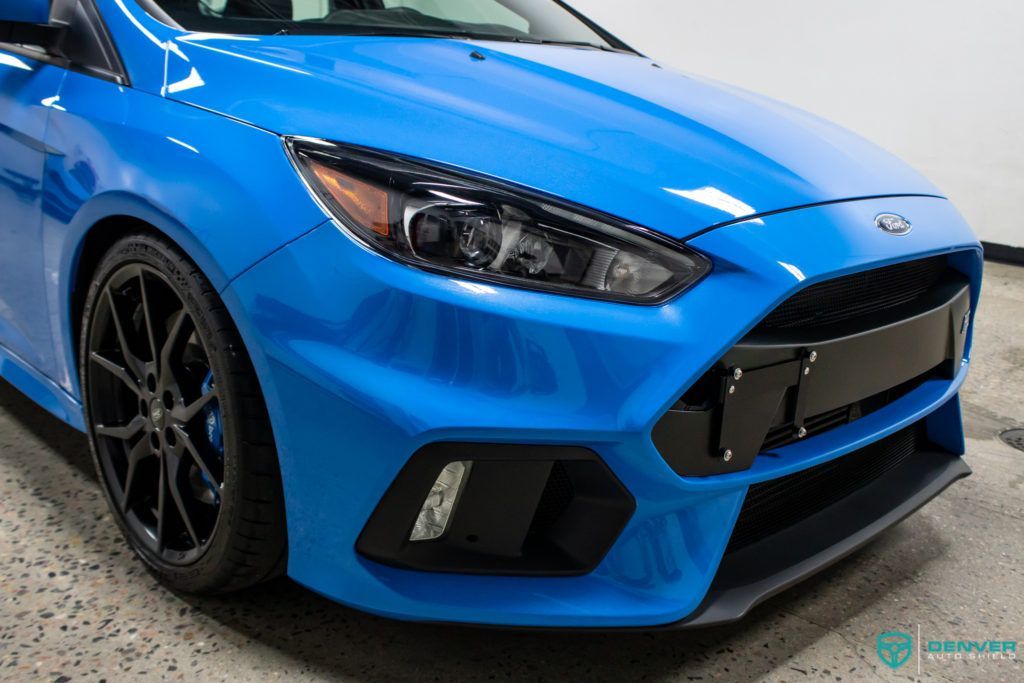 A blue ford focus rs is parked in a garage.