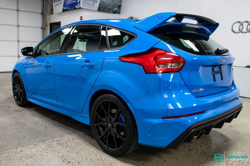 A blue ford focus rs is parked in a garage.