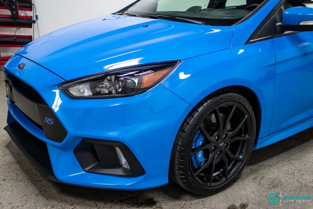 A blue ford focus rs is parked in a garage.