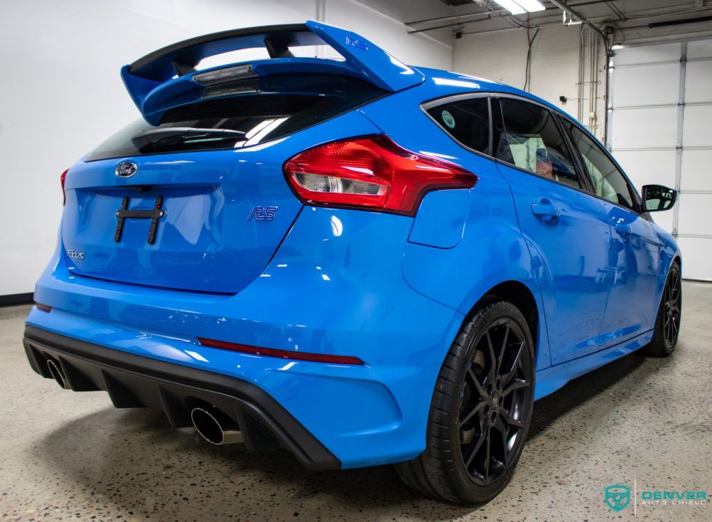 A blue ford focus rs is parked in a garage