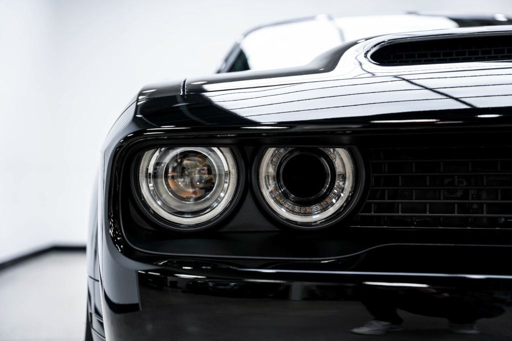 A close up of a black car 's headlights on a white background.